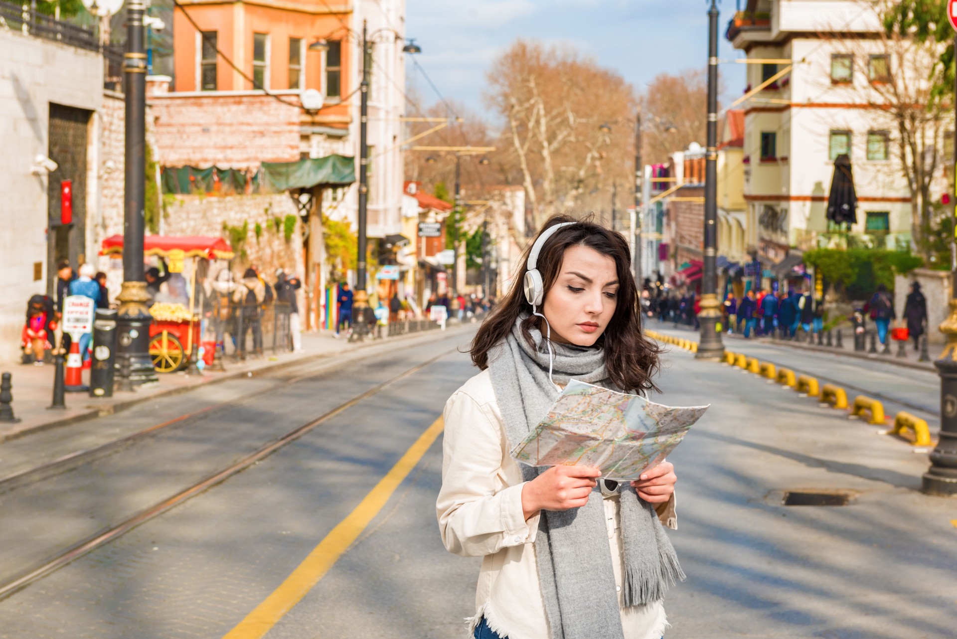 Cute girl explores streets of city with map